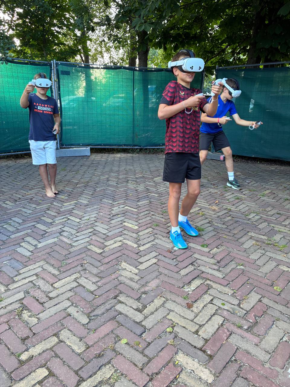 Kinderen met VR-brillen op spelen VR Multiplayer buiten op het zomerfeest van Bouwbedrijf van Engen