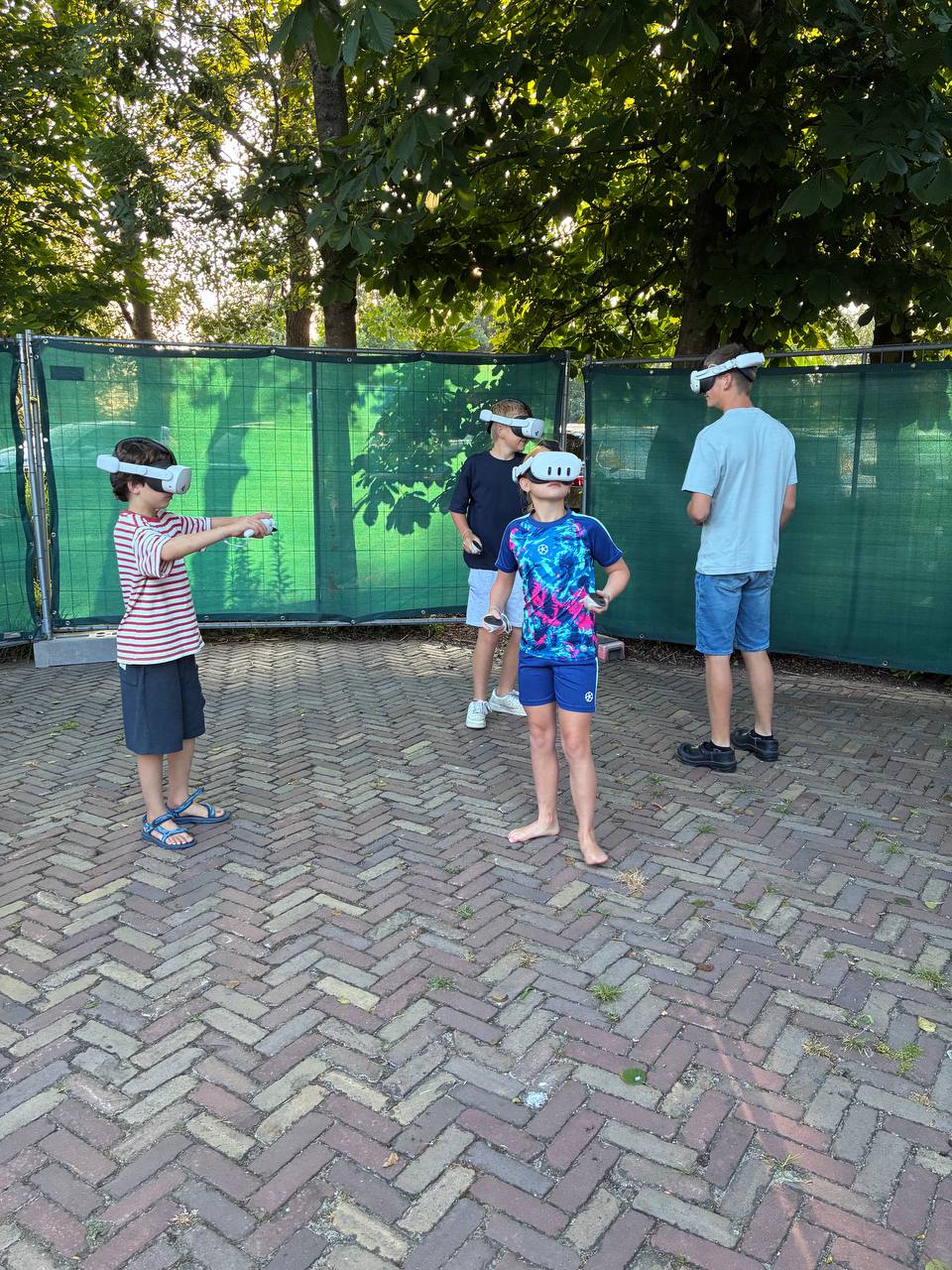 Vier kinderen spelen VR Multiplayer in de buitenlucht bij Bouwbedrijf van Engen in Kockengen